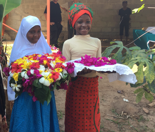 To jenter fra SOS-barnebyer tok med blomster til åpningen av solcellepanelene.